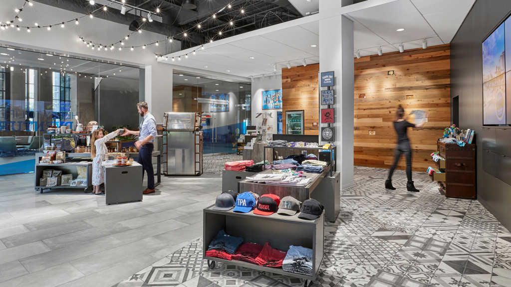 A group of people in a room with a large display of hats.